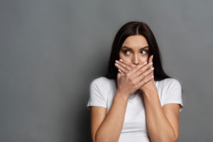 Dental Patient Shyly Covering Her Missing Teeth In Her Mouth