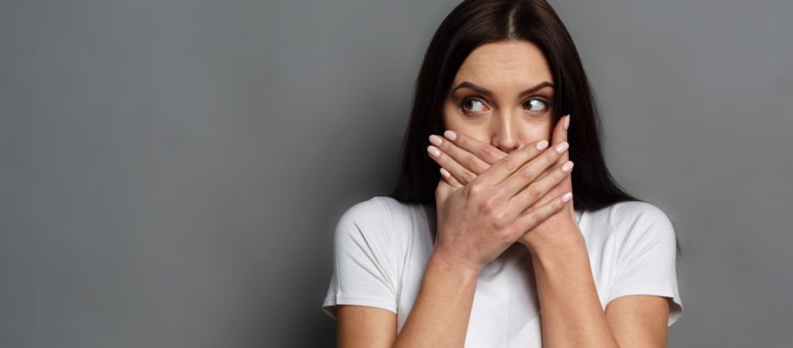 Dental Patient Shyly Covering Her Missing Teeth In Her Mouth